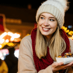 woman in sweater holding a sweet treat